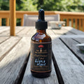 Bottle of 'Lions Mane' mushroom extract on a wooden surface with blurred greenery in the background